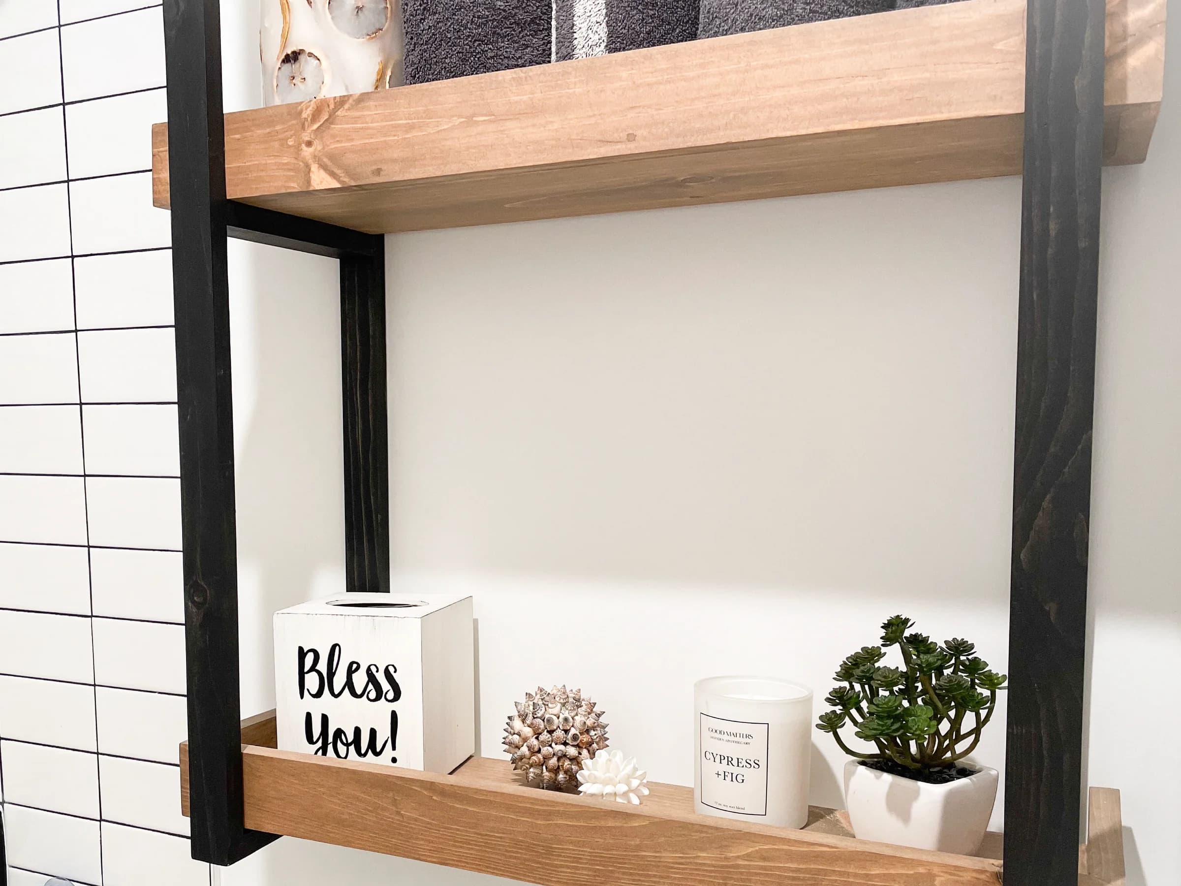 Wood shelves with black metal supports displaying plants and decorative objects