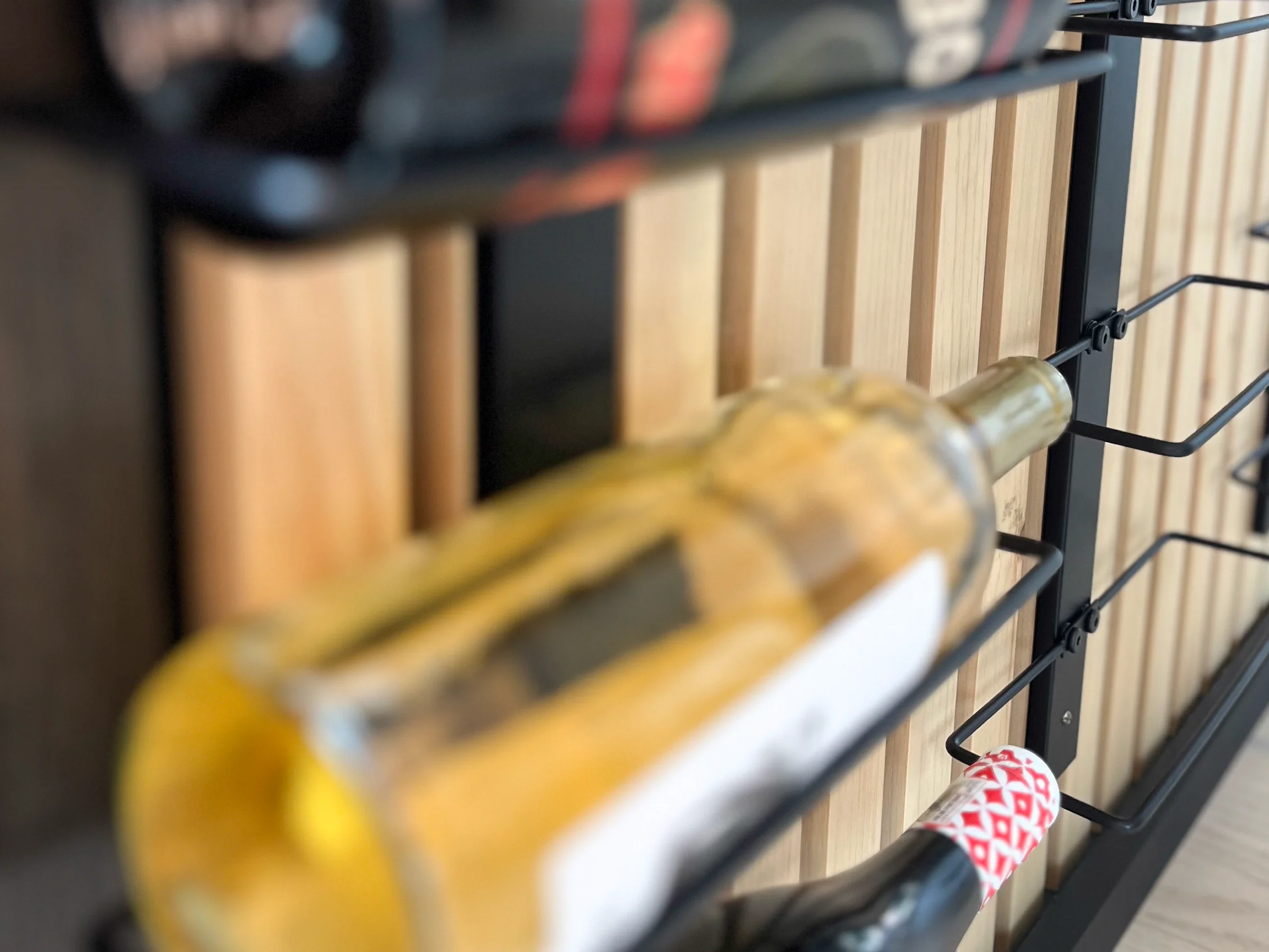 Custom wood storage with a metal rack holding bottles