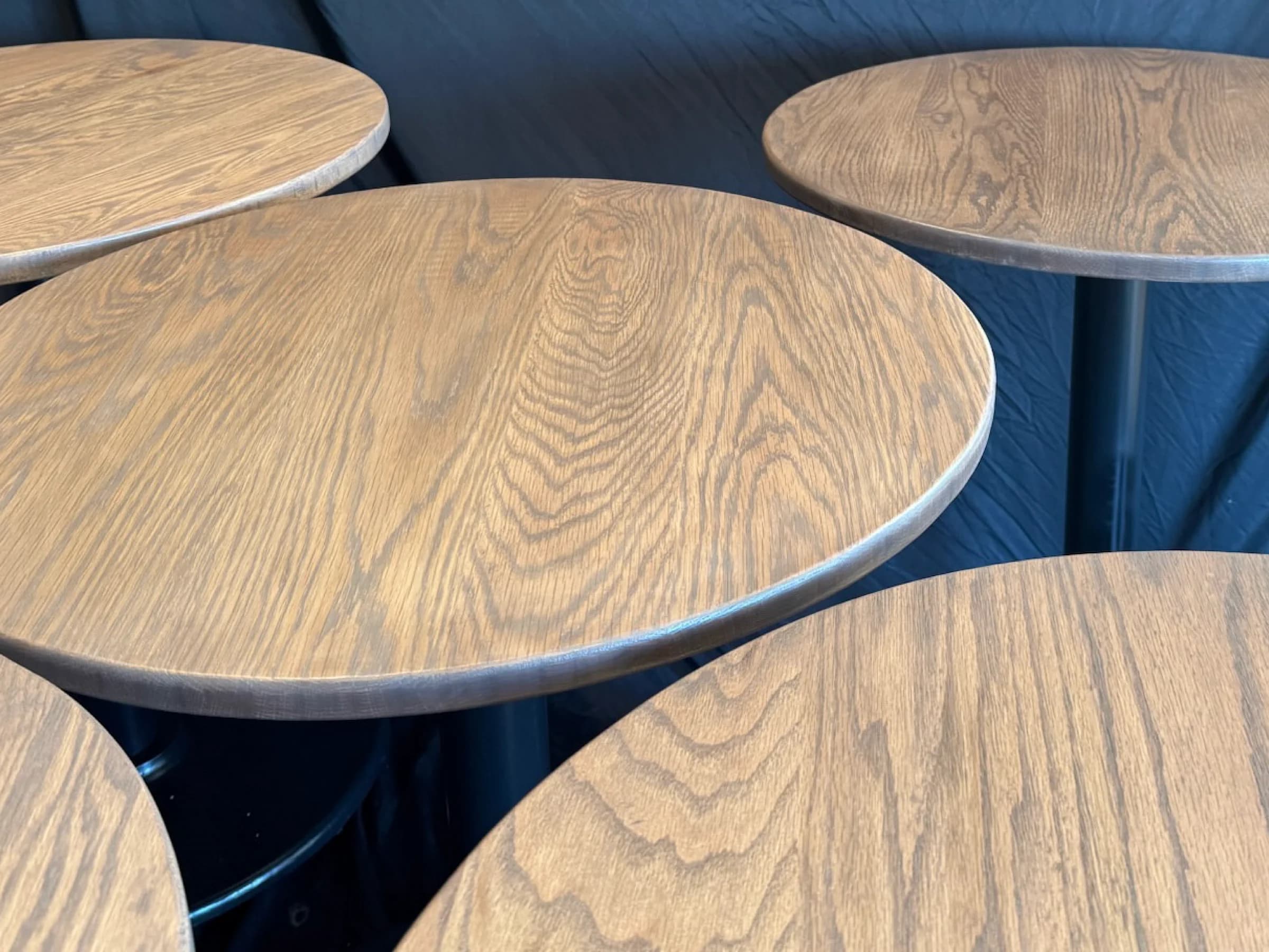 Round wood cafe tables with dark bases
