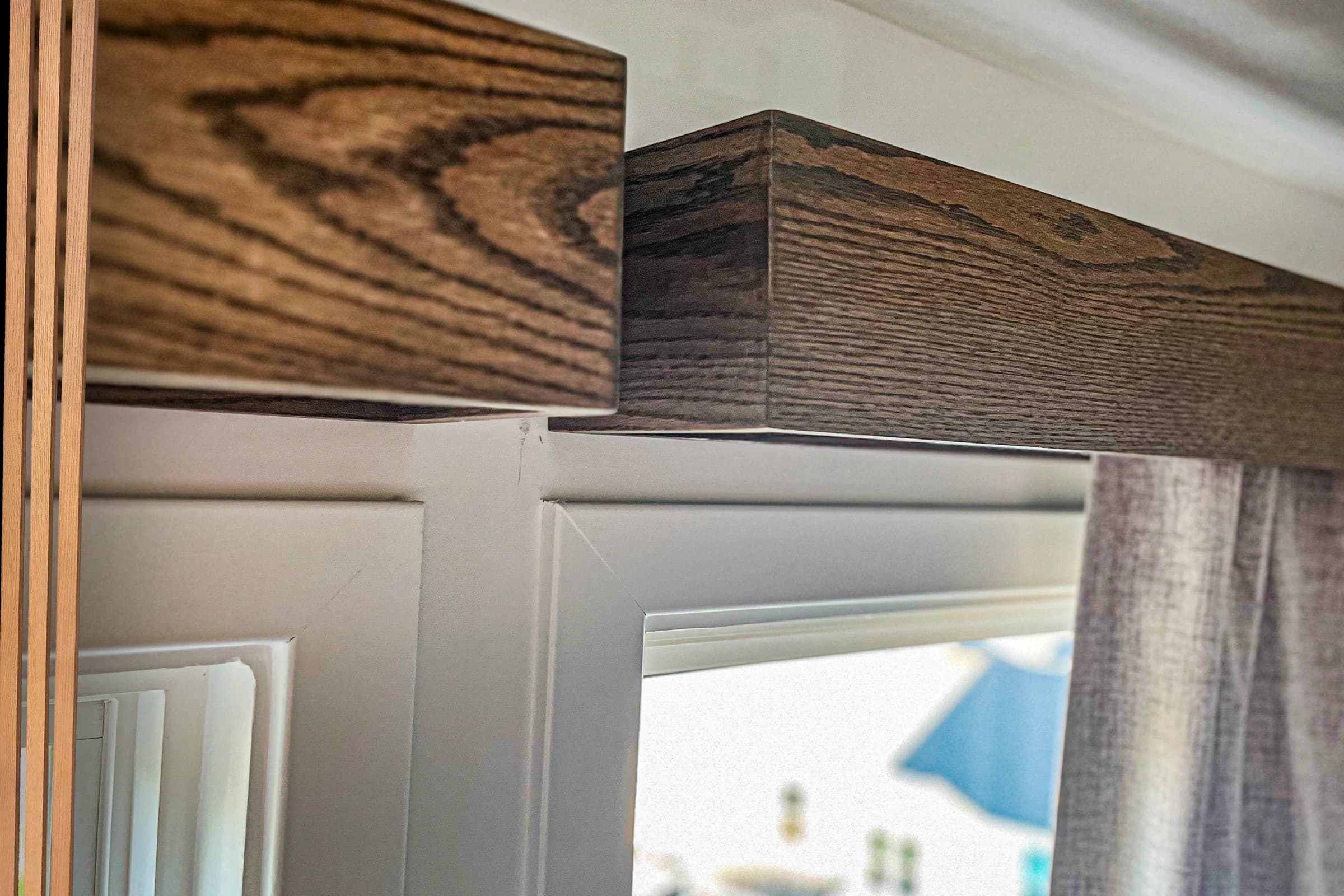 Custom wood window valance above a bedroom window and curtain