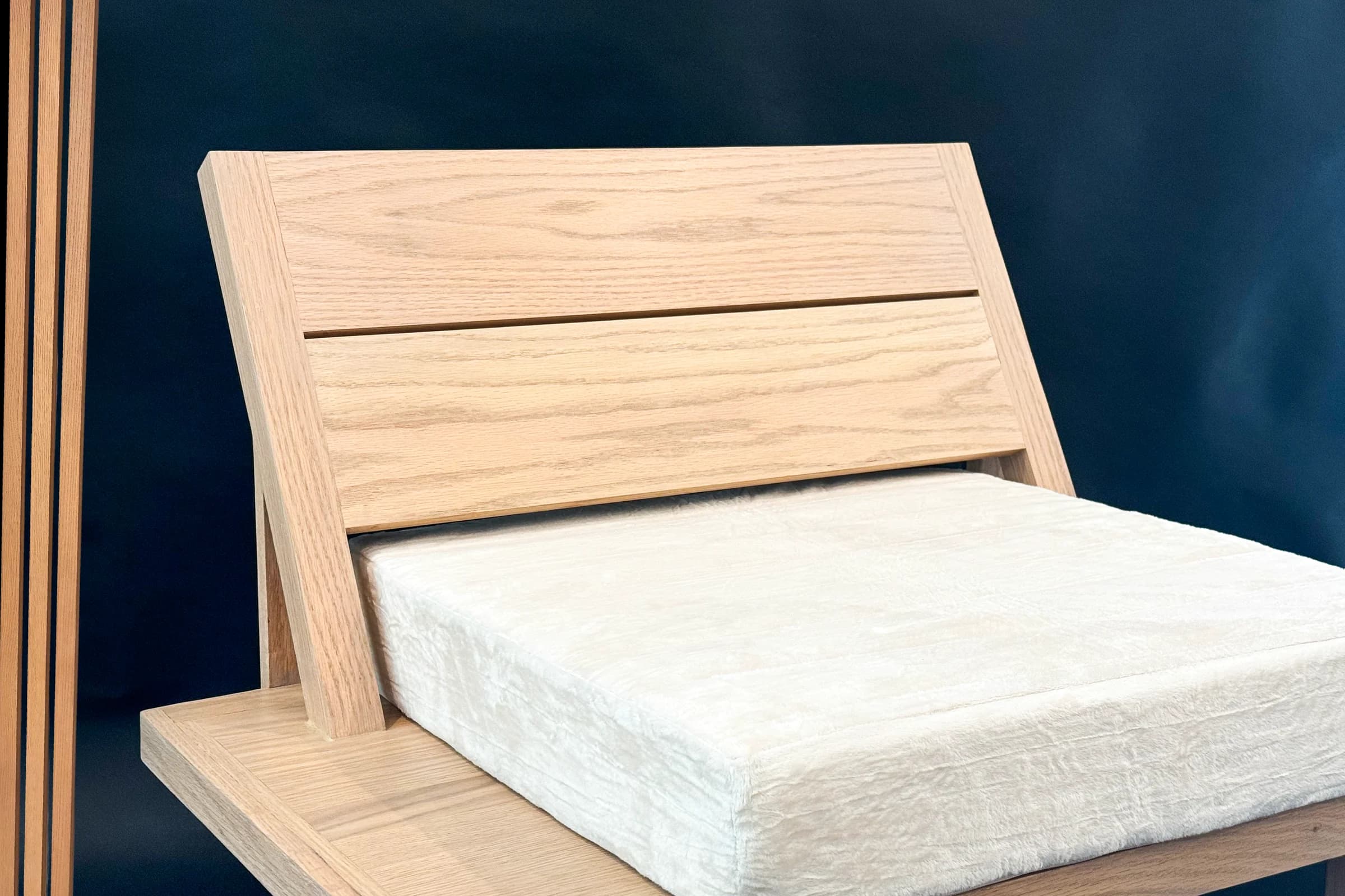 Handcrafted pale wood lounge chair with a fitted cream cushion