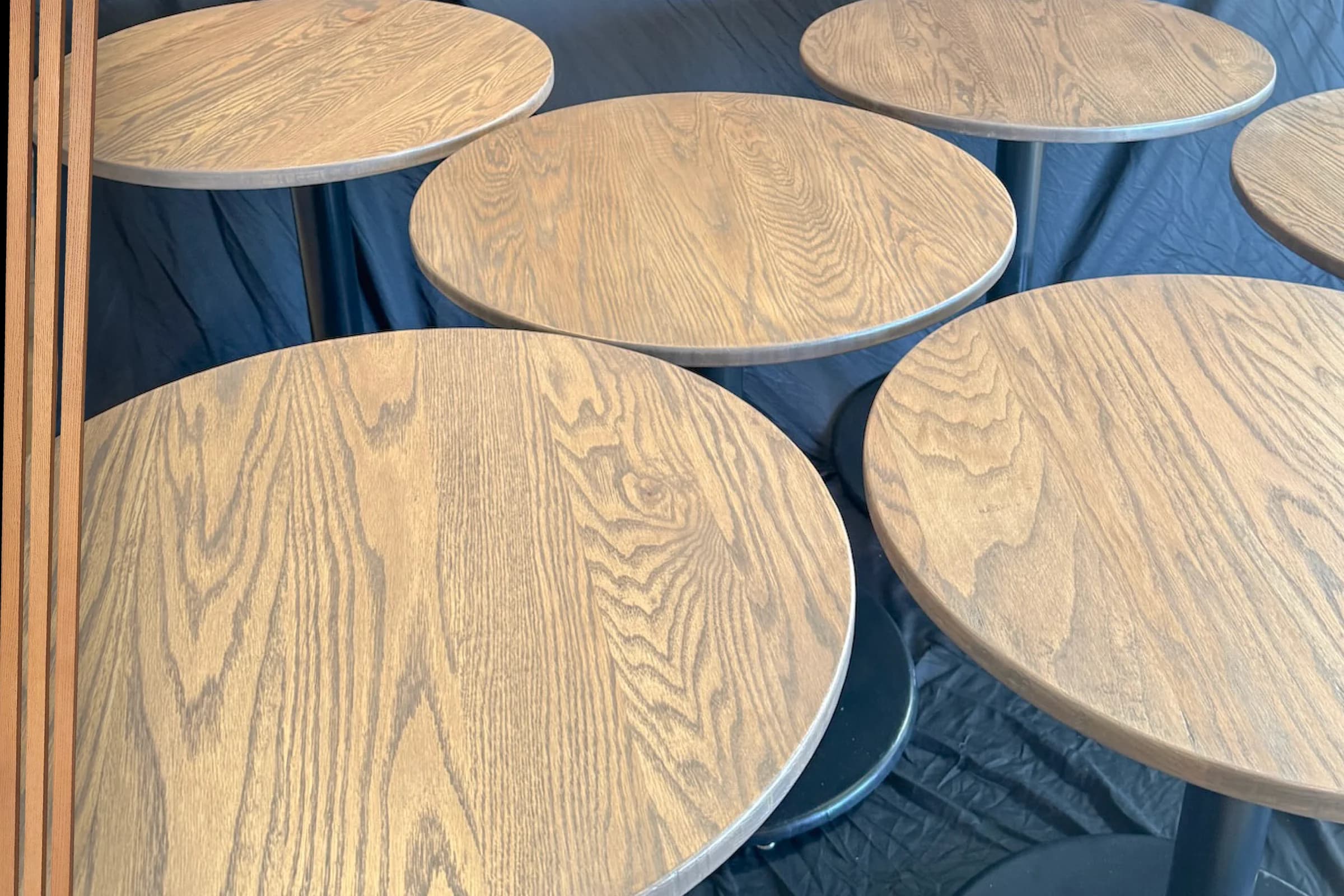 Collection of round wood cafe tables with dark pedestal bases