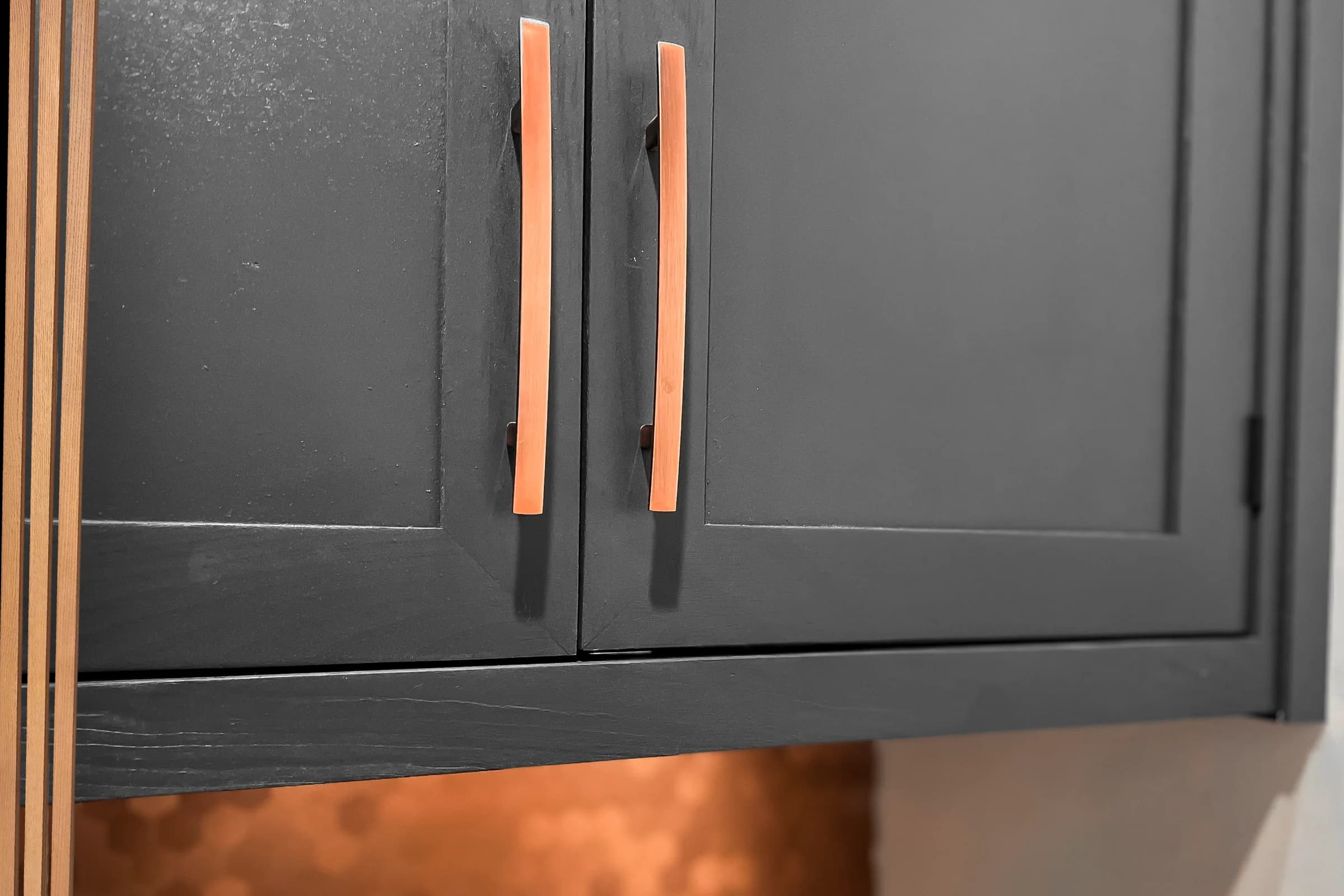 Dark laundry room cabinet doors with contrasting wood pulls