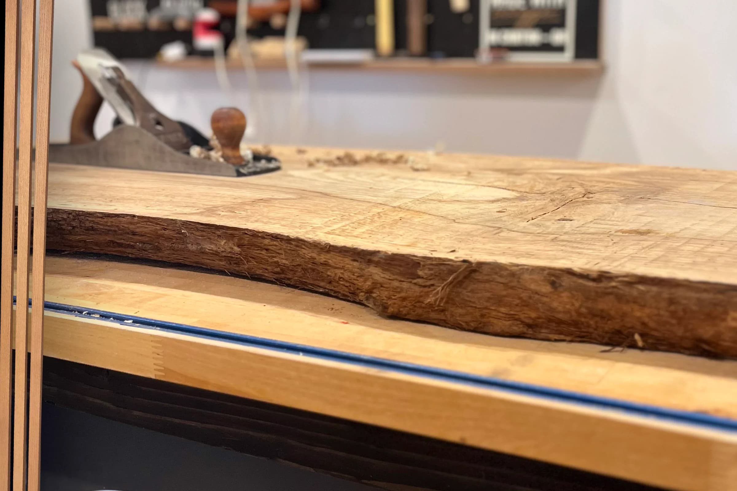 Live edge wood slab and hand plane on a workshop bench
