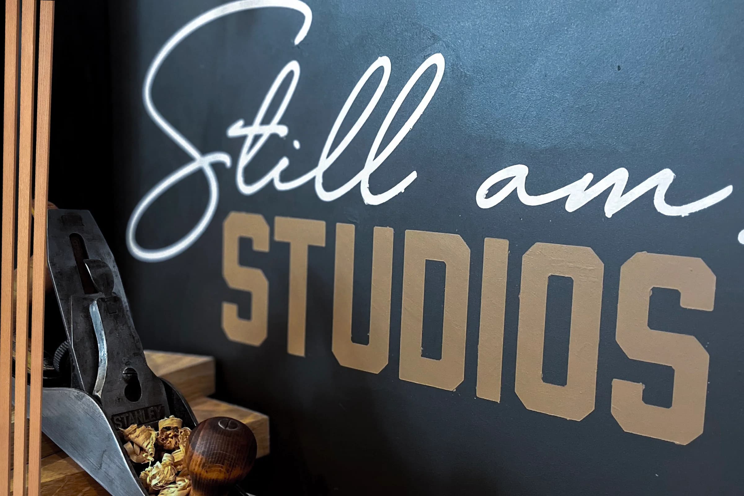 Still Am Studios painted shop sign with tools on the workbench below