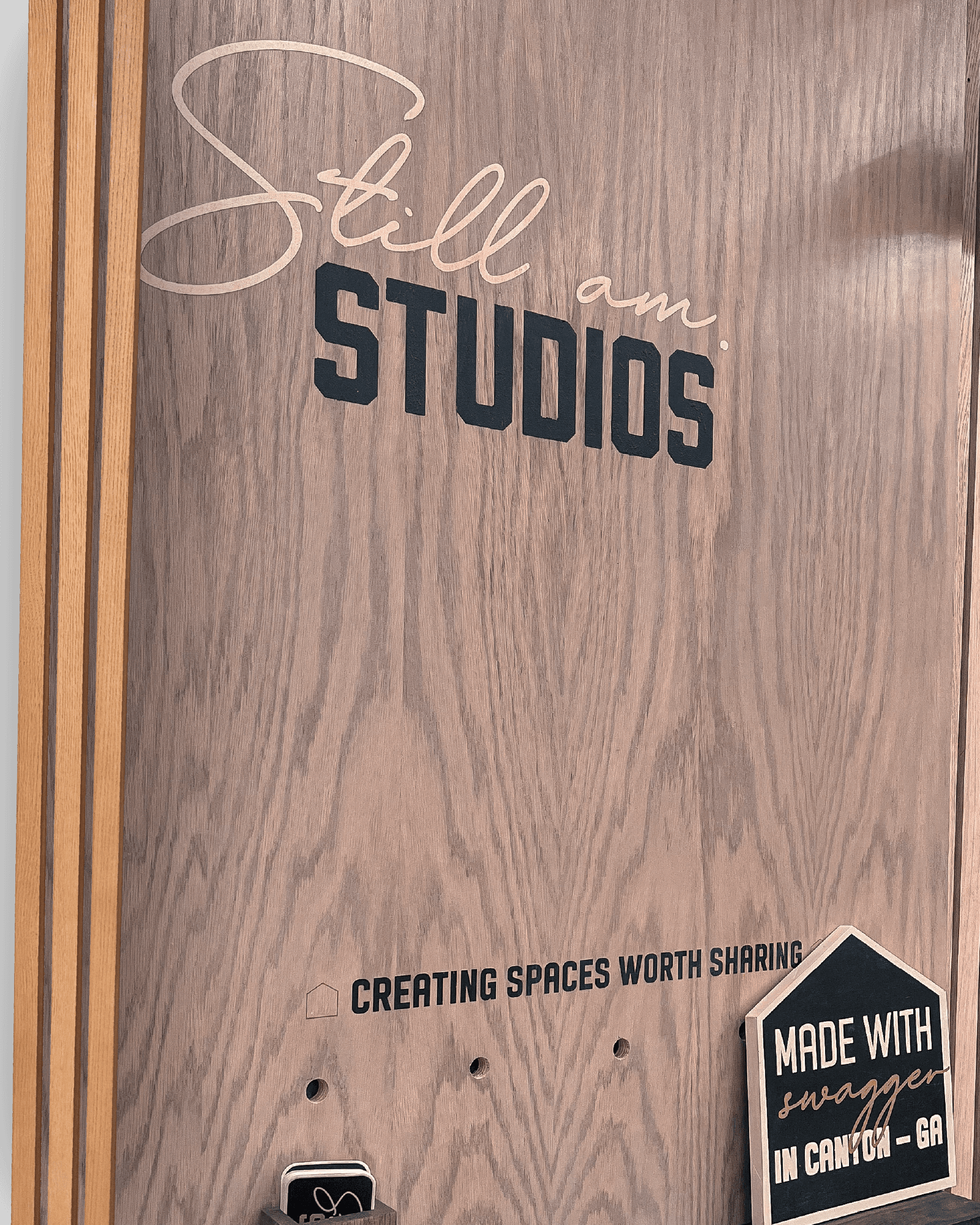 A wooden Still Am Studios sign at the workshop
