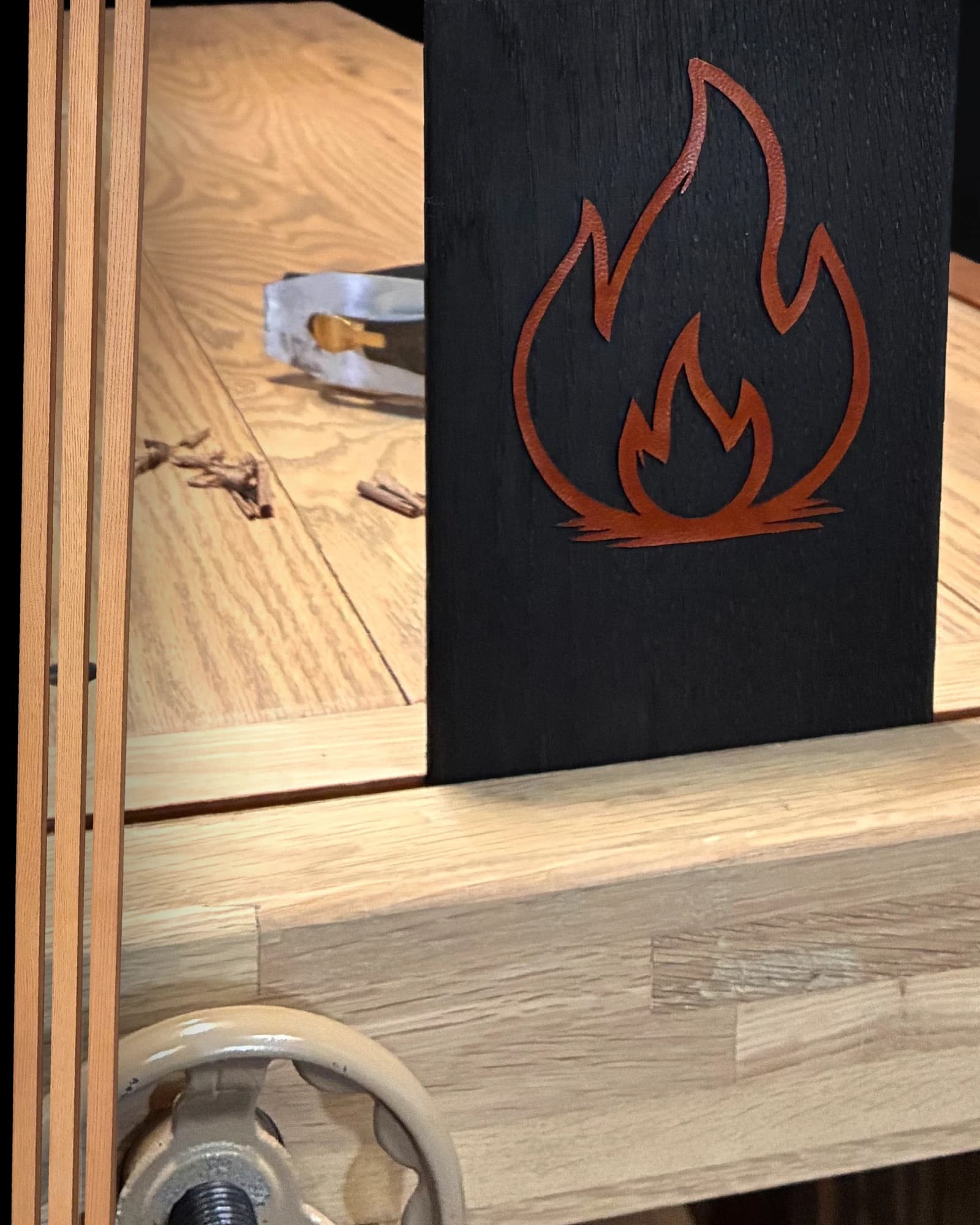 A flame illustration displayed on the workshop bench
