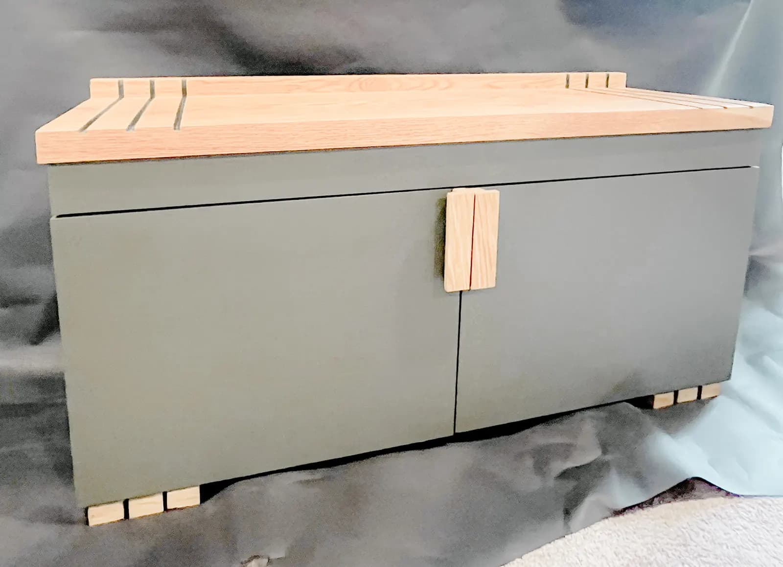 Furniture-grade green cabinet with a solid wood top and pulls